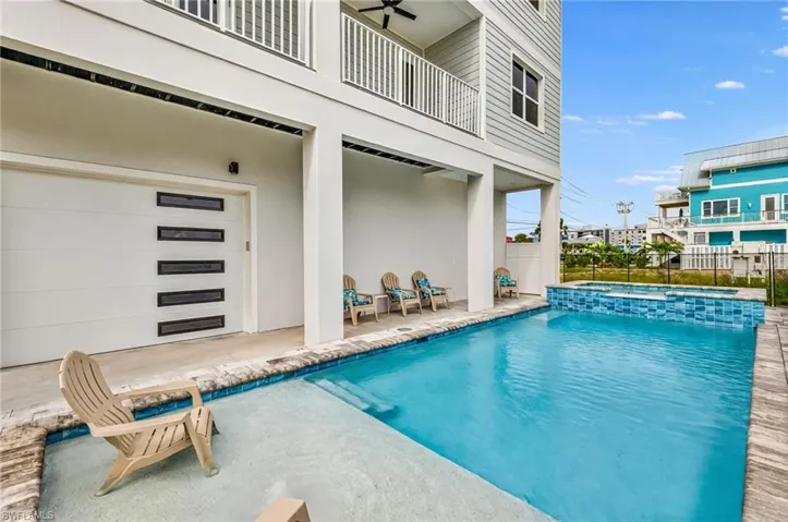 Combined pool / hot tub featuring a patio area and a balcony - Virtually Edited Image