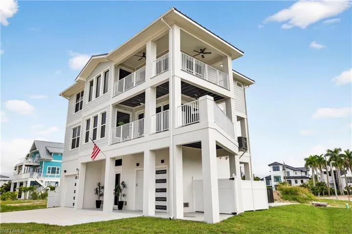 View of apartment building / complex featuring a garage and driveway - Virtually Edited Image