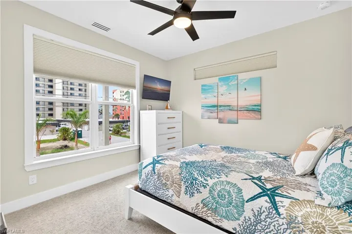 Carpeted bedroom with ceiling fan and baseboards - Virtually Edited Image