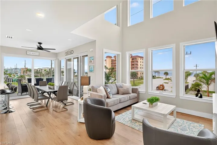 Living area featuring light wood-style flooring and a ceiling fan - Virtually Edited Image