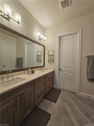 Full bath with double vanity and baseboards
