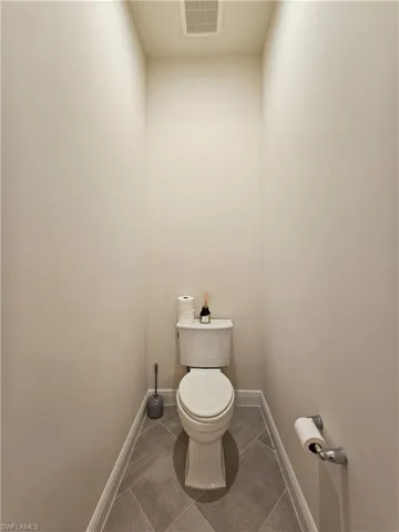 Bathroom with dark tile patterned floors and baseboards