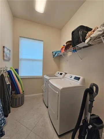 Laundry room with separate washer and dryer and light tile patterned floors