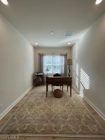 Office space with wood finished floors and recessed lighting