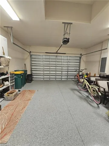 Garage featuring electric panel and a garage door opener