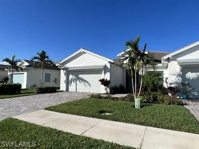 Ranch-style home with an attached garage, decorative driveway, and stucco siding