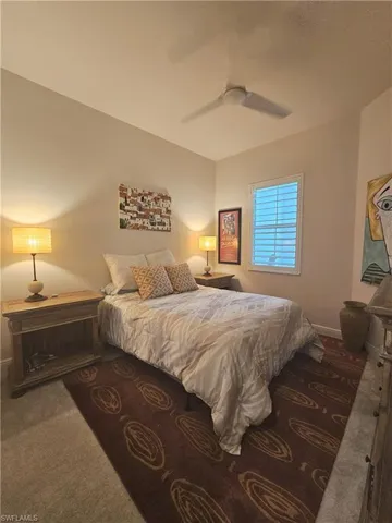 Carpeted bedroom featuring a ceiling fan and baseboards