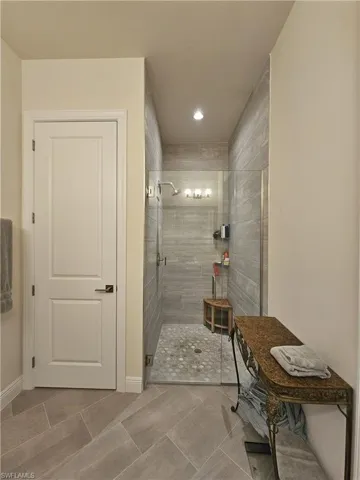 Bathroom featuring a tile shower, recessed lighting, and light tile patterned flooring