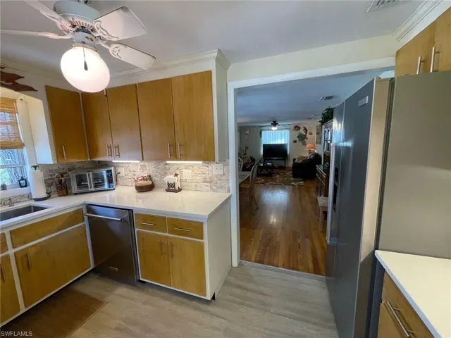 Kitchen featuring tasteful backsplash, New stainless steel appliances, a ceiling fan, and a sink