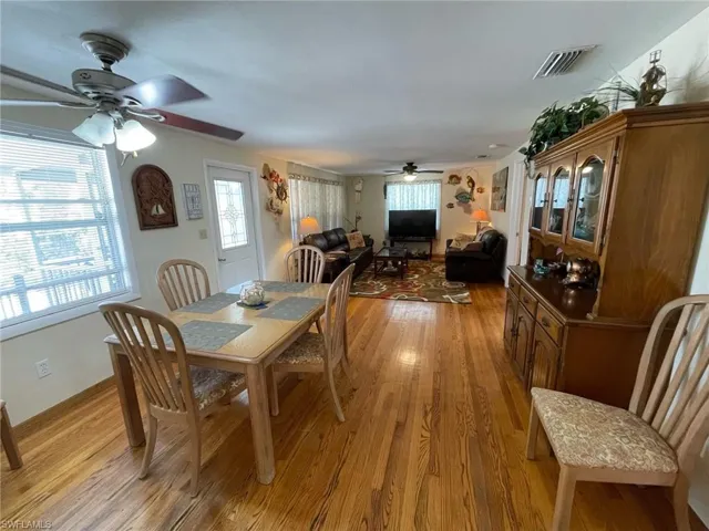 Dining space with new windows , oak wood floors and ceiling fan