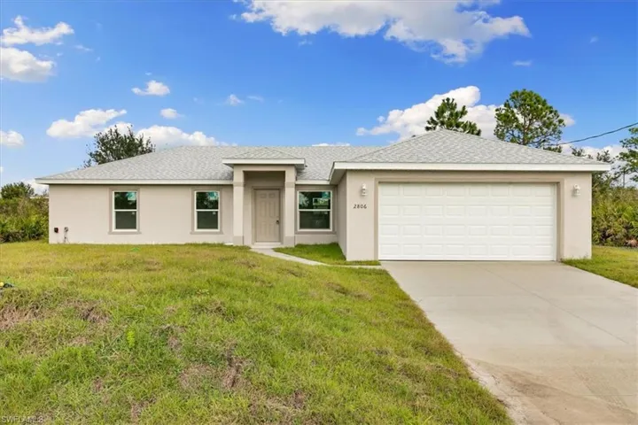 View of front of home with a front yard and a garage