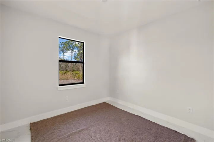 Spare room featuring marble finish floor and baseboards