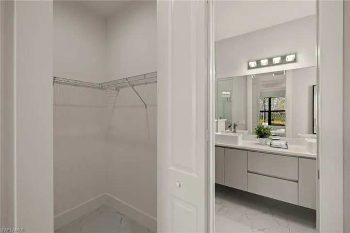 Spacious closet featuring marble finish floor and a sink
