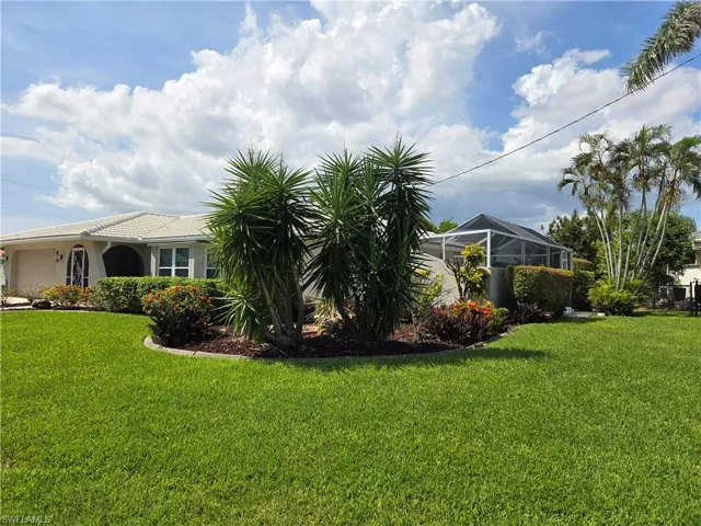 View of grassy yard featuring a garage