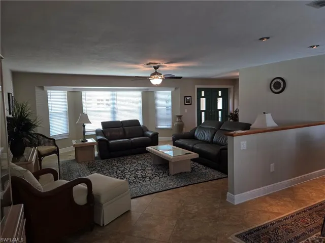 Living area with a ceiling fan and tile patterned flooring
