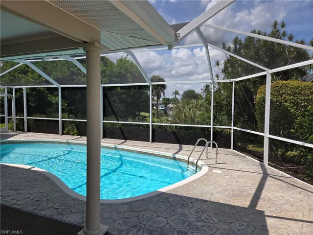 Outdoor pool featuring a patio and glass enclosure