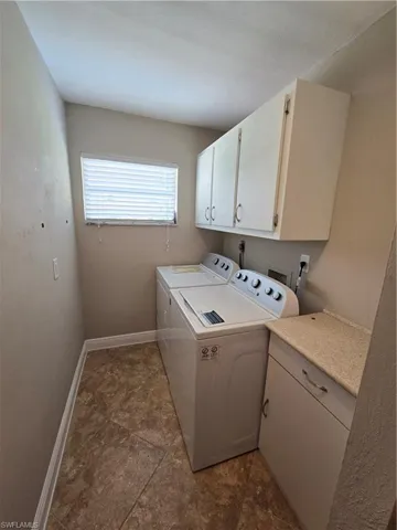 Utility Room featuring cabinet space, separate washer and dryer, Slop sink and dark stone finish floors