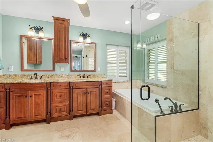 Soaking Tub with view of double sinks and cabinets