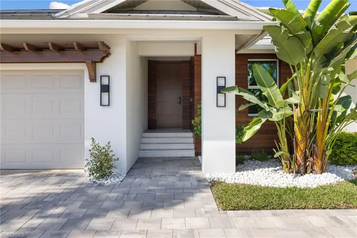 View of exterior entry featuring stucco siding and an attached garage