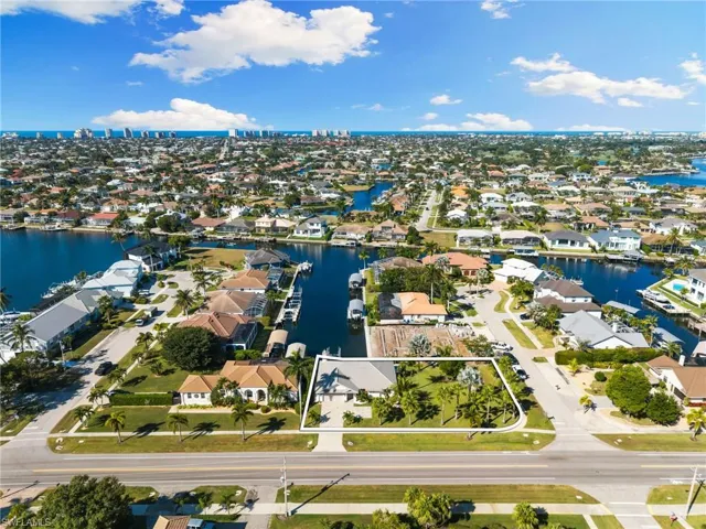 Aerial view of property's location with a nearby body of water and nearby suburban area