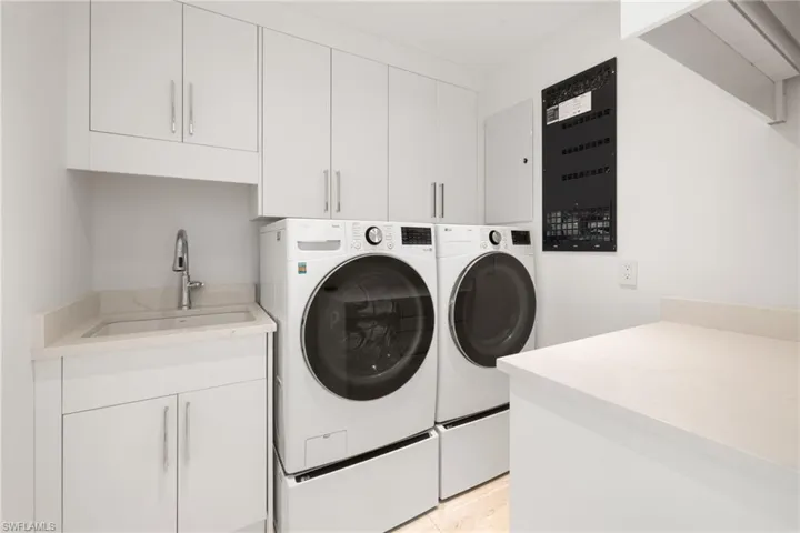 Laundry area with separate washer and dryer and cabinet space