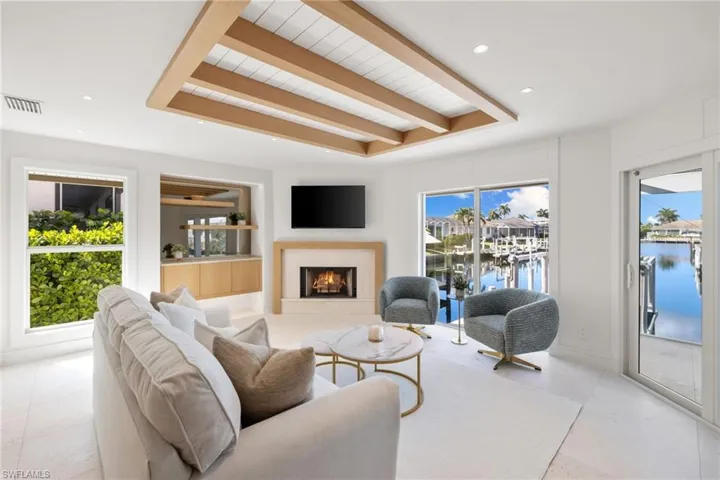 Living room featuring a warm lit fireplace and recessed lighting