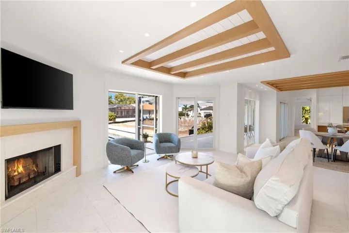 Living area featuring a high end fireplace, a tray ceiling, and recessed lighting