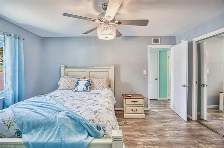 Bedroom with wood finished floors, a ceiling fan, and baseboards