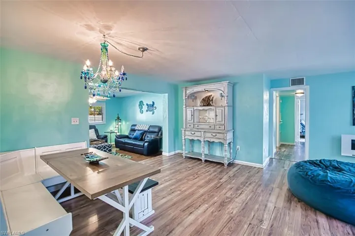 Dining space featuring a chandelier, wood finished floors, and baseboards