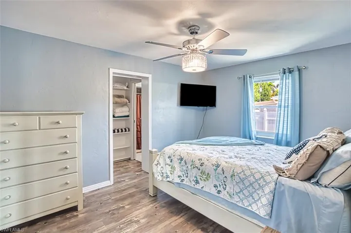 Bedroom featuring wood finished floors, a ceiling fan, and baseboards