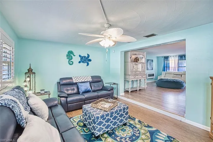 Living area with wood finished floors, ceiling fan, and baseboards