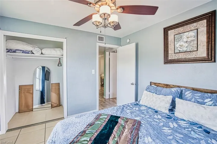 Bedroom with a ceiling fan, light tile patterned flooring, and a closet