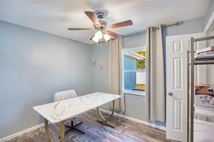Office area featuring ceiling fan, wood finished floors, and baseboards