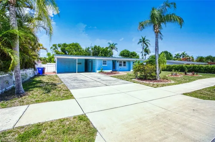 Ranch-style house featuring concrete driveway and a carport
