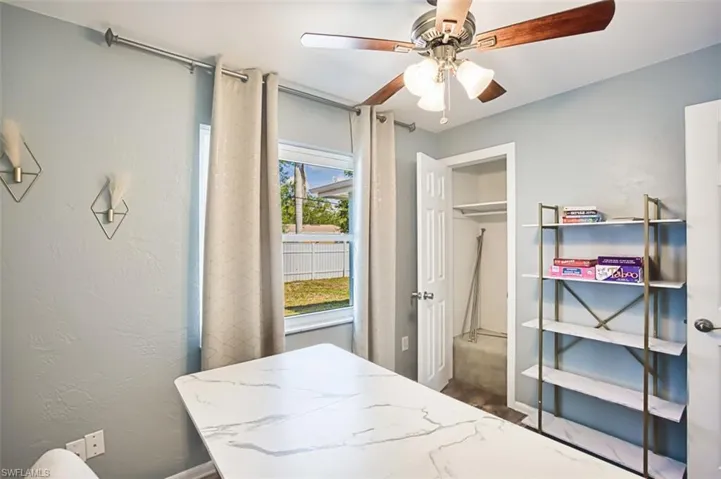 Bedroom with a ceiling fan and baseboards