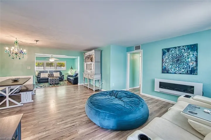 Living area with wood finished floors, ceiling fan, baseboards, and a fireplace