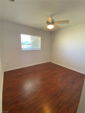Rear Guest bedroom with ceiling fan and pergo floor
