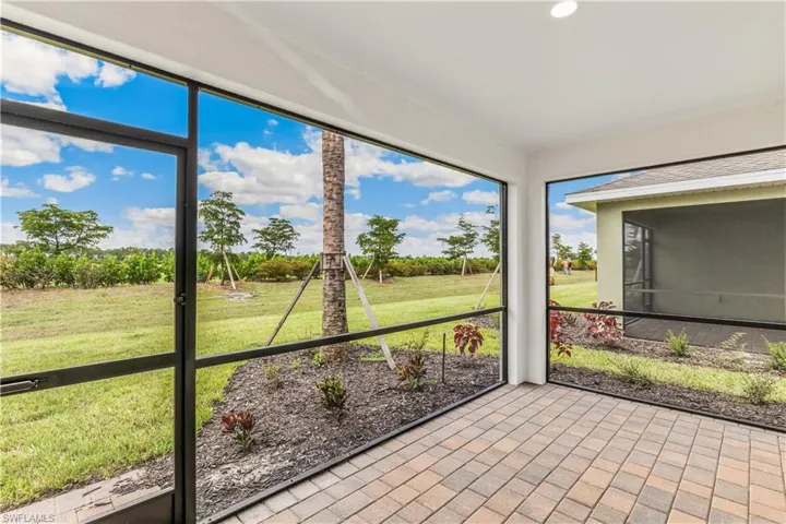 Unfurnished sunroom featuring view of wooded area