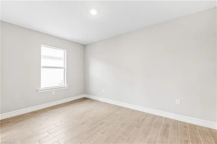 Empty room featuring baseboards and light wood-style flooring