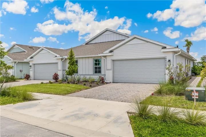 Single story home featuring board and batten siding, driveway, roof with shingles, and an attached garage