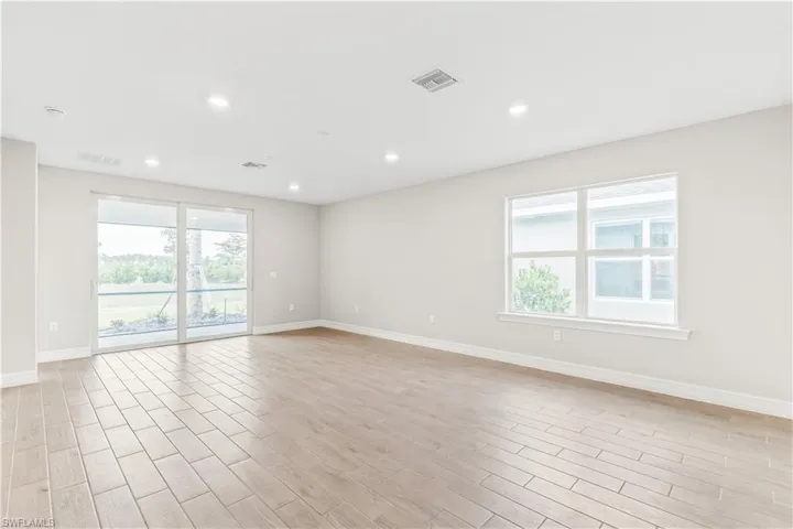 Empty room with healthy amount of natural light, light wood-type flooring, and recessed lighting