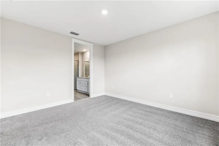 Empty room featuring light colored carpet and recessed lighting
