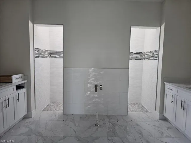 Bathroom featuring tile floors and a tile shower