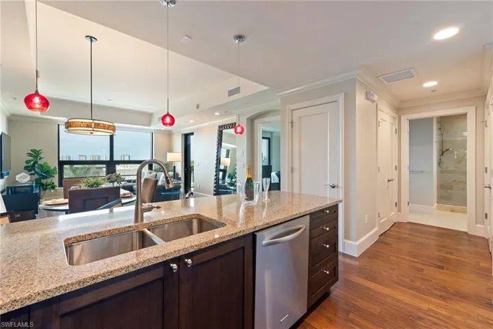 Kitchen featuring ornamental molding, recessed lighting, stainless steel dishwasher, open floor plan, and dark brown cabinetry