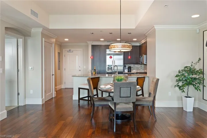 Dining room featuring ornamental molding, dark wood-type flooring, and recessed lighting