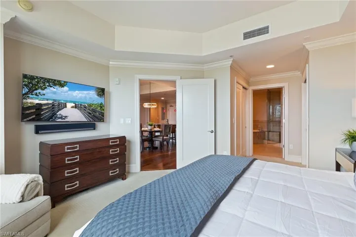 Bedroom with crown molding, recessed lighting, ensuite bath, and light carpet