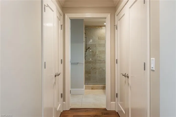 Hallway with dark wood-style flooring ,Laundry area on the right and A/C plus water heater area to the left