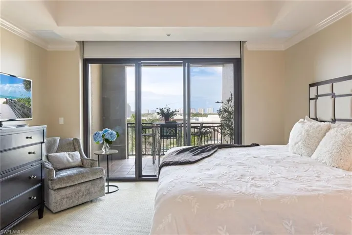 Carpeted bedroom with ornamental molding and access to exterior