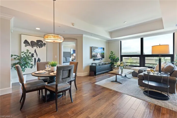 Dining area with dark wood-style flooring, crown molding, and recessed lighting