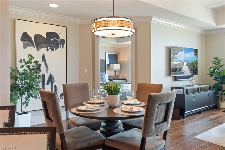 Dining area with crown molding and wood finished floors